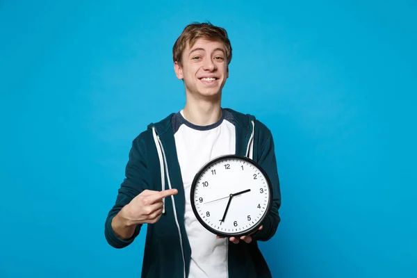 Sonriente joven con ropa casual sosteniendo, apuntando índice fing — Foto de Stock