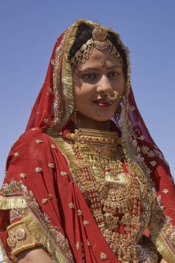 Jaisalmer, Rajasthan, Hindistan - 19 Şubat 2008: Süslü kırmızı sari giymiş ve Jaisalmer yıllık Çöl Festivali'nde geleneksel Hint mücevher ile süslenmiş Hintli bayan.