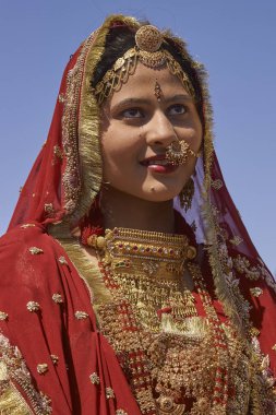 Jaisalmer, Rajasthan, Hindistan - 19 Şubat 2008: Süslü kırmızı sari giymiş ve Jaisalmer yıllık Çöl Festivali'nde geleneksel Hint mücevher ile süslenmiş Hintli bayan.