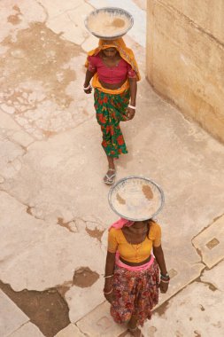 JAIPUR, RAJASTHAN, INDIA - 30 Temmuz 2008: Hindistan 'ın Jaipur kentindeki Amber Kalesi' nde bir sarayın restorasyonu sırasında kafalarında su ve alçı taşıyan kadın işçiler.