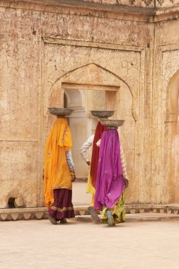 JAIPUR, RAJASTHAN, INDIA - 30 Temmuz 2008: Hindistan 'ın Jaipur kentindeki Amber Kalesi' nde bir sarayın restorasyonu sırasında kafalarında su ve alçı taşıyan kadın işçiler.