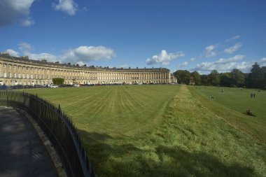 Bath, Birleşik Krallık - 25 Eylül 2020: Royal Crescent in Bath, Somerset, İngiltere. İnsanlar çimenlerde oturur güneşli bir sonbahar gününün tadını çıkarırlar.. 