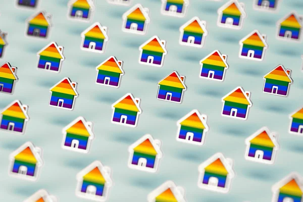 Blurry closeup shot on group of gay pride rainbow in a home shape isolated on pastel green background. LGBTQ people rights to live together concept. 3D rendering — Stock Photo, Image