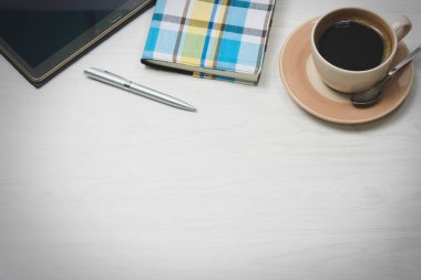 Tabletli, kalemli, kahveli bir ofis masası. Kopyalama alanı olan üst görünüm