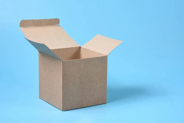 青い背景に厚紙箱を開ける — ストック写真