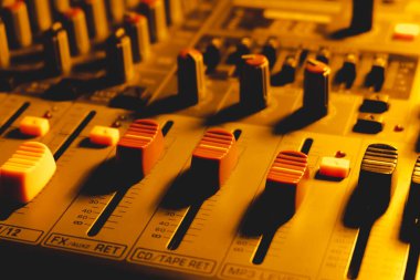 Loş ışıkta profesyonel ses karıştırma konsolu.