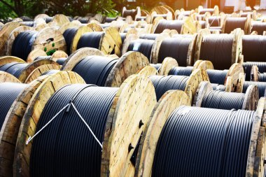 Dışarıdaki elektrik kablosunun ahşap bobinleri. Depodaki yüksek ve düşük voltaj kabloları.