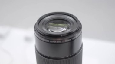 Dijital kameralar için yeni telefoto objektif yakın çekim ve Sergi üzerinde bir vitrinde daha az sistem ayna. Beyaz arka planda siyah telefoto lens.