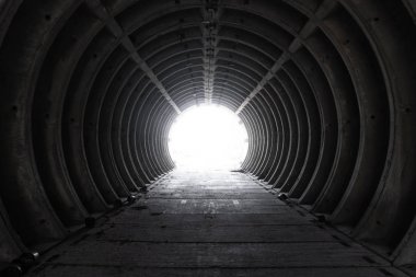 Dışarıdaki boş beyaz beton boru tünelinden çıkın. Sonunda ışık ile sığınaktan çıkın. Boş beton boru tünelinin içinde. Bir kıyamet hissi ile terk edilmiş tünel.