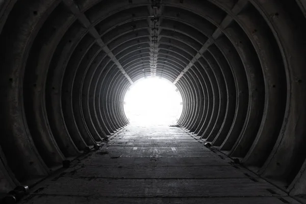 Dışarıdaki boş beyaz beton boru tünelinden çıkın. Sonunda ışık ile sığınaktan çıkın. Boş beton boru tünelinin içinde. Bir kıyamet hissi ile terk edilmiş tünel.