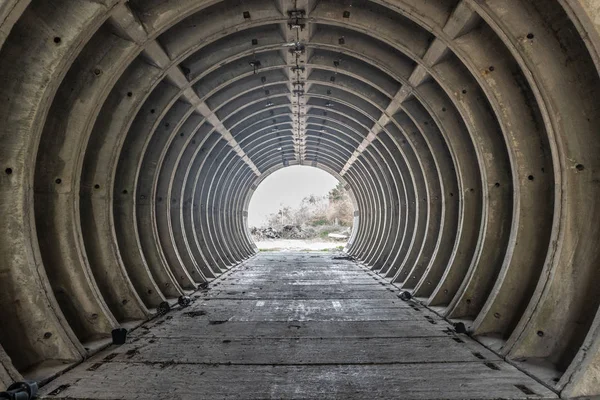 Dışarıdaki boş beyaz beton boru tünelinden çıkın. Gün içinde sığınaktan çıkın. Boş beton boru tünelinin içinde. Bir kıyamet hissi ve karanlık sinematik grunge etkisi ile terk edilmiş tünel.