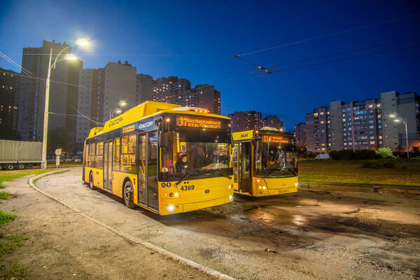 Kyiv, Ukraine - June 2, 2020: Yellow trolleybus on the streets of Kyiv in the residential area of Troieschyna at night. Trolleybus "Bogdan".