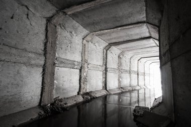 Tünelin sonunda bir ışık parlayan kare beton drenaj tüneli..
