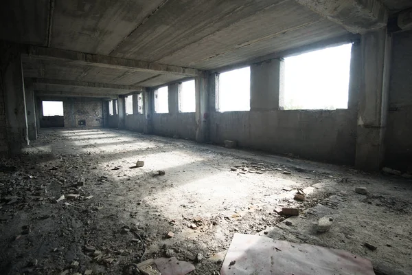 窓から光に照らされた未完成の廃屋の内部 — ストック写真