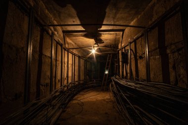 Koyu beton kablo tüneli tungsten lamba ile aydınlatılır..