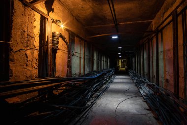 Ön planda kablo bağlantısı olan yeraltı kablo tüneli. İnternet, televizyon ve telefon için optik kabloları olan yeraltı tüneli.