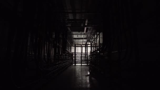 多くのケーブルのある地下トンネルを提灯を持った男が歩いている — ストック動画