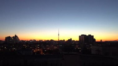Gün batımında şehir silueti, merkezinde TV kulesi, zaman ayarlı..