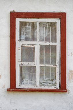 Basit ahşap pencere, kırmızı çerçeveli ve beyaz pul pul boyanmış. 1800 'lerin sonlarından kalma kırsal evlerin tipik özelliği. Pereyaslav, Ukrayna, 31 Mart 2024