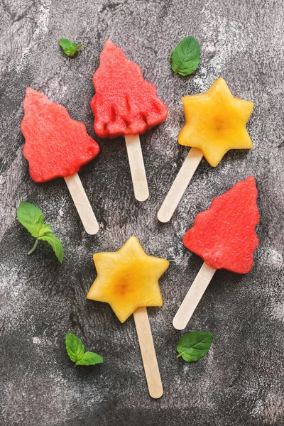 Watermelon and peach ice cream in the shape of a Christmas tree and a star. Summer fruit dessert on a stick.
