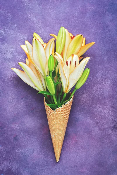 Head of yellow lily in a waffle cup on a beautiful abstract purple background