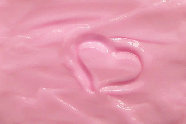 Pink moisturizing cosmetic cream with a painted heart. Beautiful cream texture. Concept. Valentine\'s Day