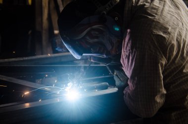 Metal parçalar katılmak için kaynak makinasıyla işçi