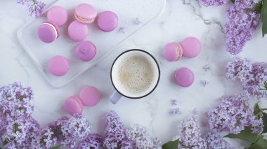 Eflatun çiçekler, açık renkli mermer bir zemin üzerine macaroons