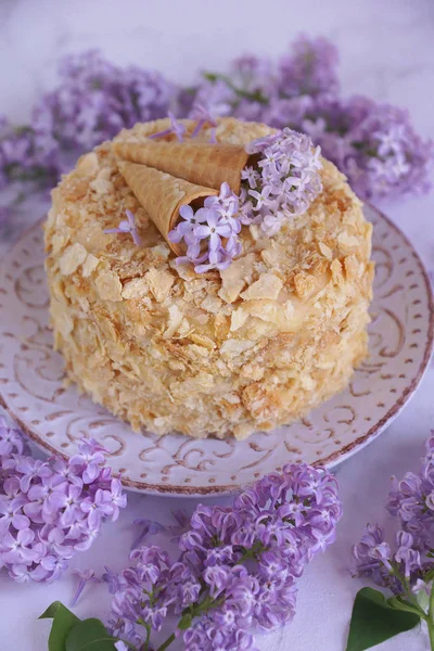 Hand made cake, Napoleon, Millefeuille, Cream slice cake on marble background with lilac flowers