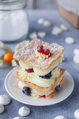 Çay ve tatlılar hafif bir arka plan üzerinde milföy, eklerleri, Tart, dekoratif çiçeklerle, seçici odak