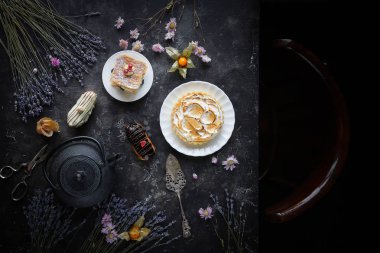 Çay ve tatlılar karanlık bir arka plan, Mille-feuille, Eclairs, Tart, Çiçek ile Dekoratif, Üst görünüm, Vintage