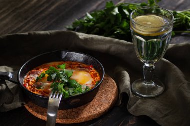 Shakshuka dökme demir bir tavada yumurta kızarttı.