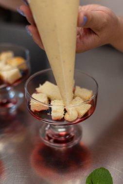 Pasta şefi kremayı porsiyonlu formlara doldurur.