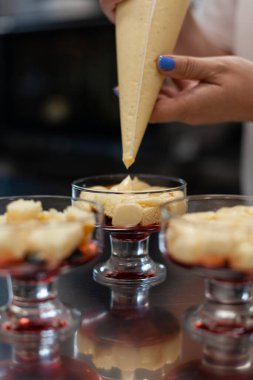 Pasta şefi kremayı porsiyonlu formlara doldurur.