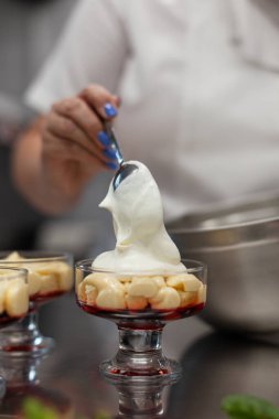 Pasta şefi kremayı porsiyonlu formlara doldurur.