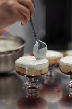 Pasta şefi kremayı porsiyonlu formlara doldurur.