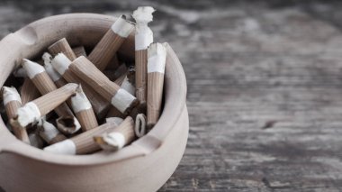 Kül tablası ile sigara izmaritleri yakın çekim. Kül tablası ile sigara. Kül tablası içinde sigarası. Kötü alışkanlık. Sigara için zarar. Ara.
