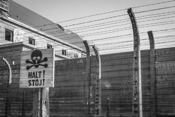 Torture and death at the Factory of Death. Escape from the concentration camp of Auschwitz-Birkenau. Warning sign in the concentration camp. Danger sign in front of poles with electric current. Auschwitz-Birkenau Concentration Camp. Horrors of war.