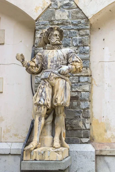 Statue of a man in the courtyard of Peles Castle in Sinai. Marble statue near the castle. The castle in Romania. Sights of Romania.