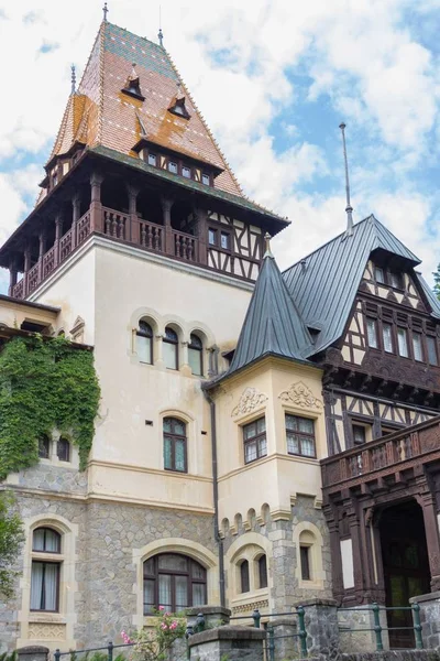 High castle against the sky. Historic building in Romania. Medieval castle in Europe. Architecture of the Middle Ages. An old house. Luxury estate. An old house. Peles Castle.