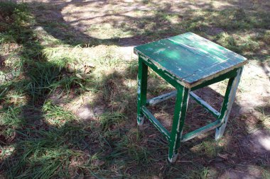 Eski dışkı. Boş koltuk eski püskü yeşil boya. Vintage mobilya. Bahçe mobilyaları. Paçavra sokakta.