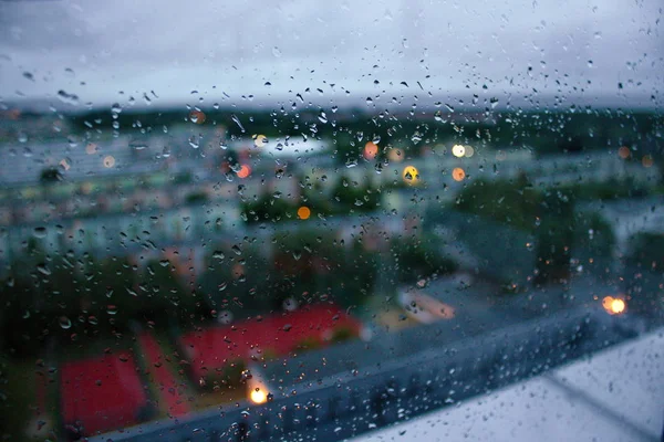 Rain drops on the glass. Drops of rain on the glass, rain outside the window, autumn melancholy, rainy weather, apathy, cloudy sky, cold. Rainy weather outside the window. Gloomy sky in the clouds. Rainy and rainy season. Large rainfall.