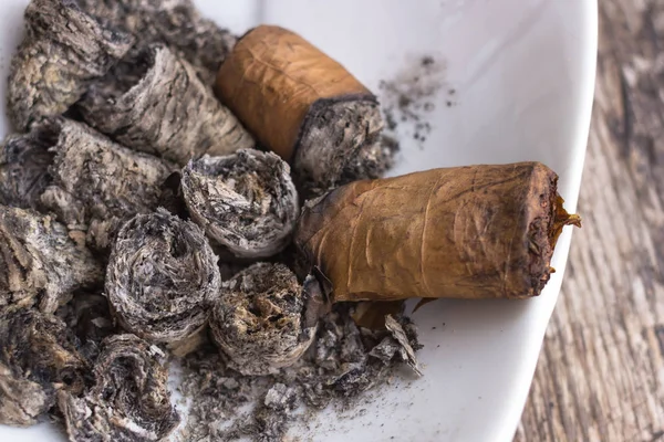 Ash cigars in the ashtray. Dear Cuban cigar. Cigar good twist. Tobacco leaves. Smoking a cigar. The bad habit of a gentleman. Texture of cigar ash. Men\'s weakness.