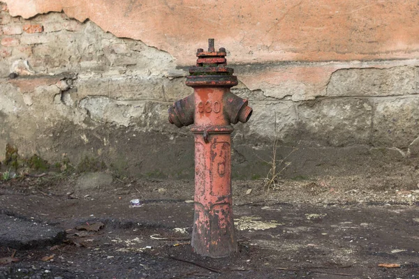 Red hydrant on the street. Fire extinguishing agent. Pipe with water. Fire system in the old days. Old hydrant. Fire safety.