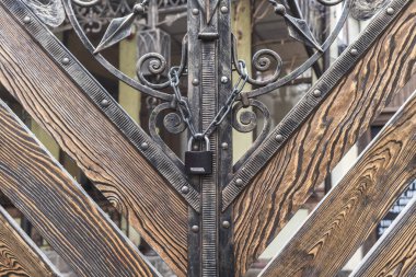 Kapalı giriş. Ahşap Kapı demir kilit. Sahte köy gates. Çit bölge. Zinciri üzerinde kilit. Tarihi bir binada Vintage dış.