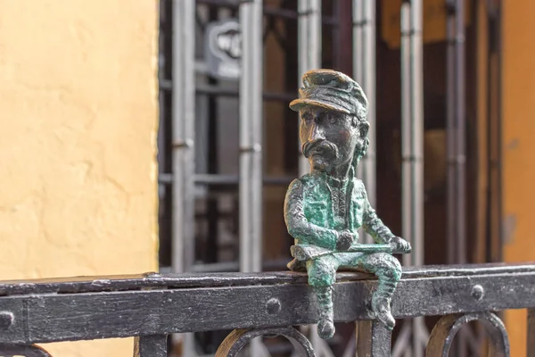 Bronze figure of man. Forged product. City monument. Entertainment for tourists. Exterior decor in the city. Statues in Uzhgorod in Western Ukraine. Funny little man.