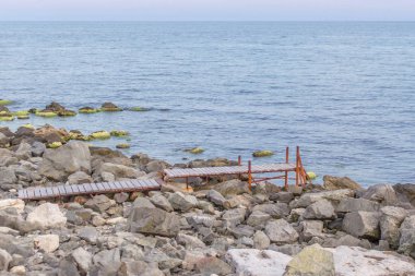 Tahta köprüden denize. Okyanus kıyısında. Yalnızlık bir yer. Deniz yolu. Dünyanın ucu. Taş Plajı. Balıkçılık iskele. Pier tekneler için. Karadeniz'in kıyı şeridi.