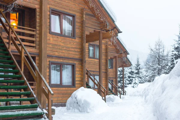 Chalet kayak merkezinde. Ahşap ev tatil Bukovel Ukrayna. İki katlı evler günlükleri. Doğal yapı malzemeleri. Kış ülke manzarası. Karla kaplı evler. Ahşap cephe.