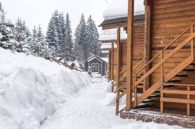 Chalet kayak merkezinde. Ahşap ev tatil Bukovel Ukrayna. İki katlı evler günlükleri. Doğal yapı malzemeleri. Kış ülke manzarası. Karla kaplı evler. Ahşap cephe.