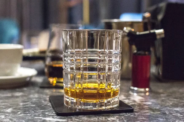A glass of whiskey, bourbon, brandy, rum or brandy. Expensive drink in the bar. Male strong alcohol. Refined taste. Long exposure. Elite distillery. Scotch or Irish whiskey.